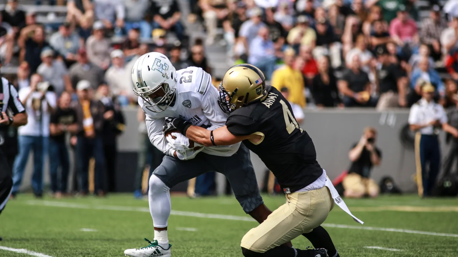 An Eastern Michigan ball carrier fights through an Army tackle during a 2017 game.