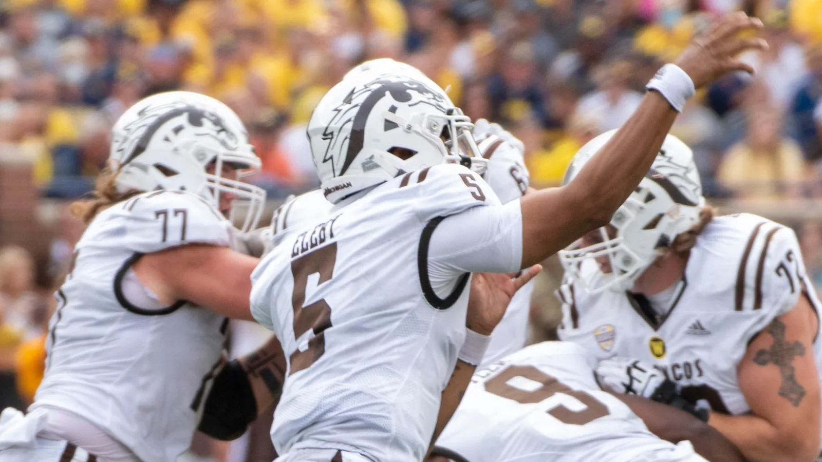Western Michigan players in white Broncos uniforms against Michigan in 2021.