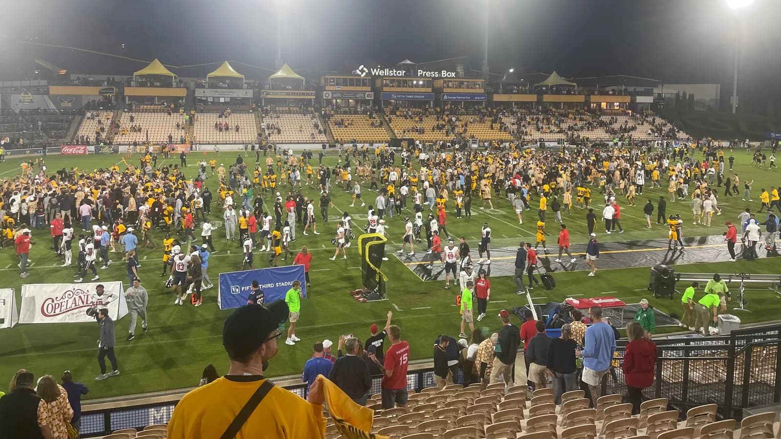 Fans fill the field at Fifth Third Stadium after a Kennesaw State win.