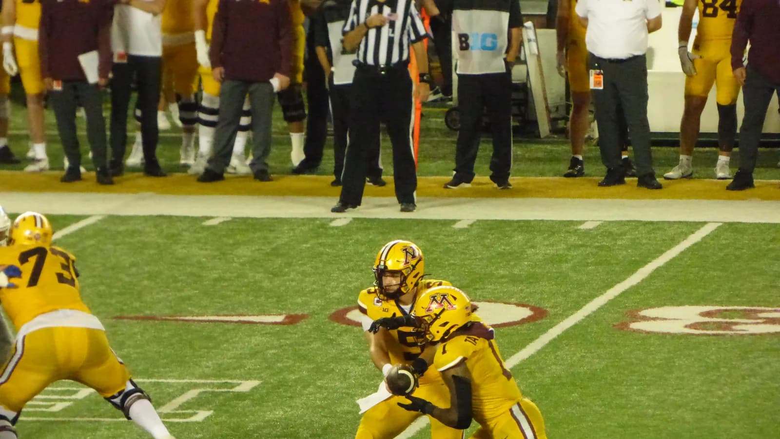 Minnesota quarterback Drake Lindsey hands the ball to Darius Taylor in 2025.