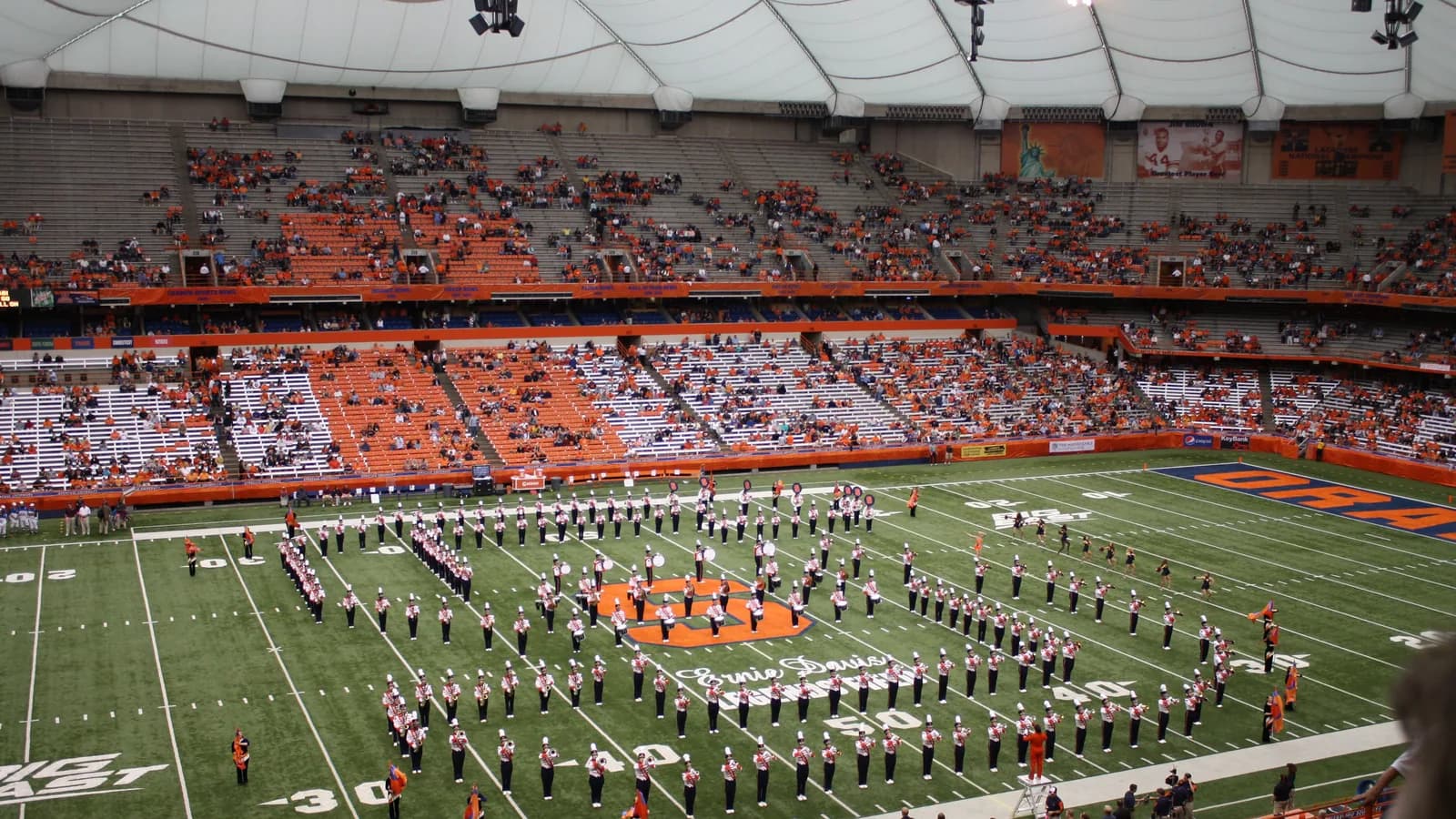 The Syracuse marching band forms a block S on the field before a game.